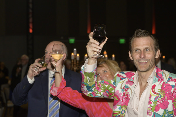 Three people raise their glasses in a toast at the 2024 Auction.